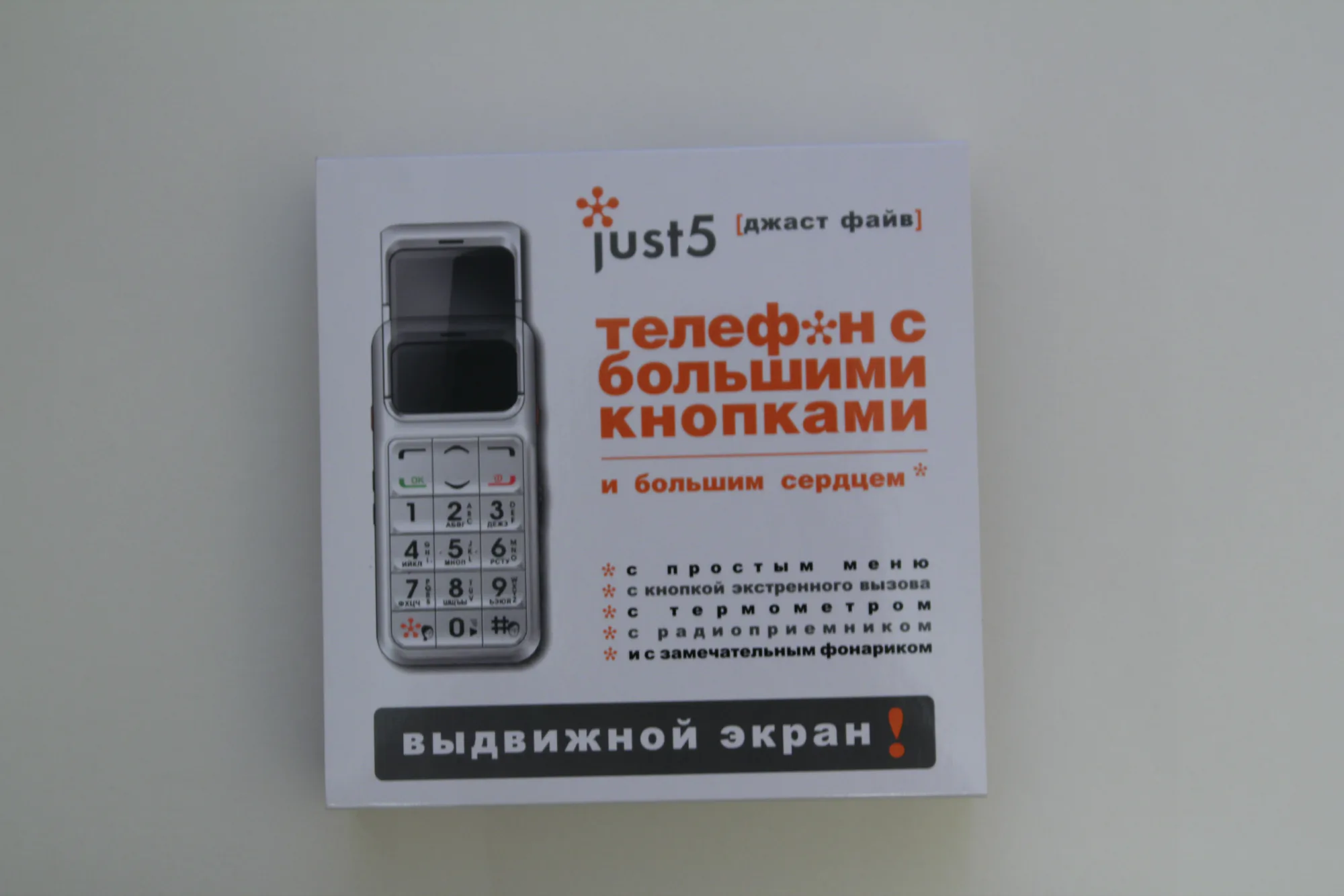 Коробка телефона Just5 с большими кнопками: выдвижной экран, простое меню, кнопка экстренного вызова, термометр, радио, фонарик.