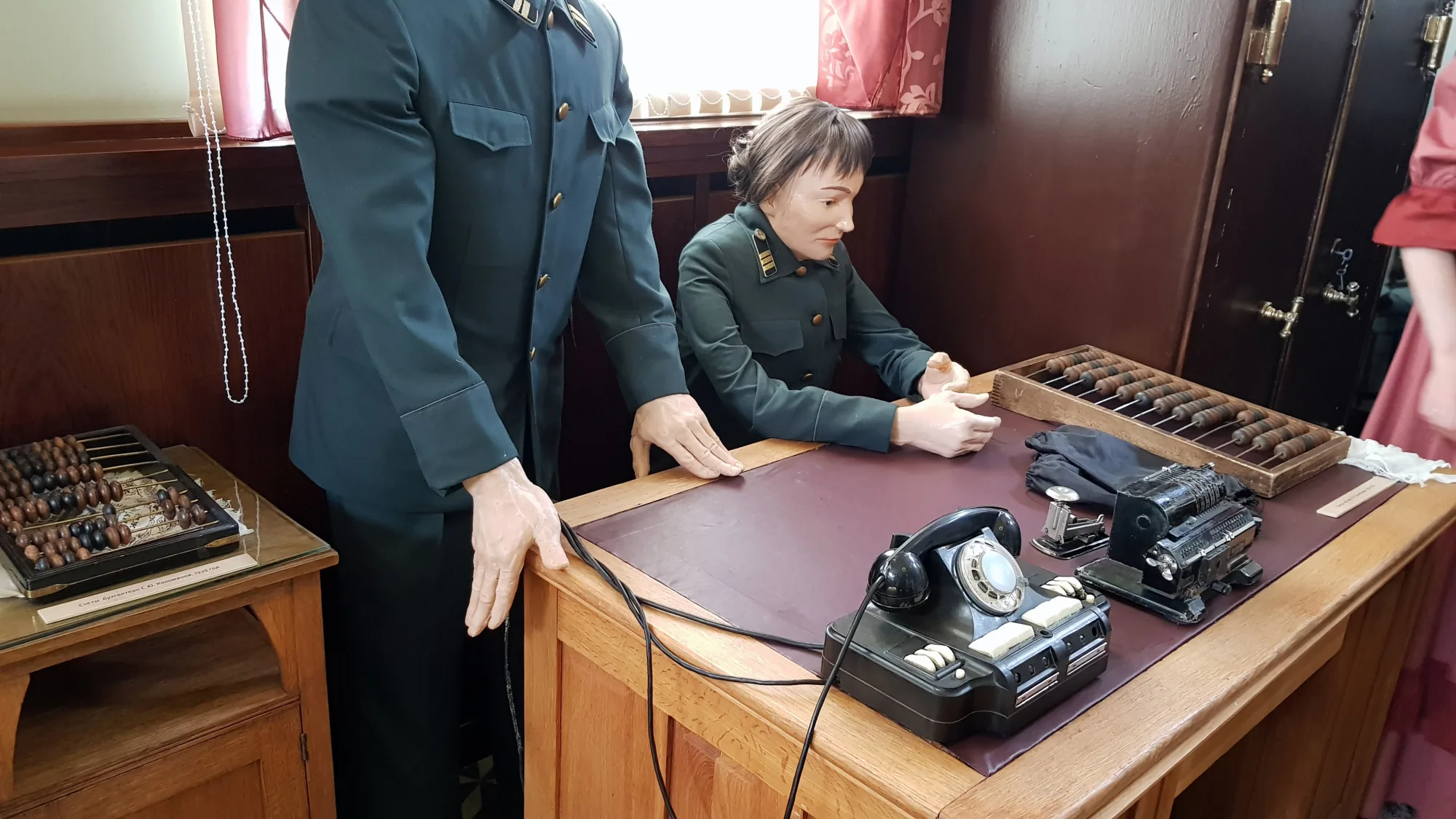 Манекены в военной форме за столом с телефоном, телеграфным аппаратом и счетами в музее.