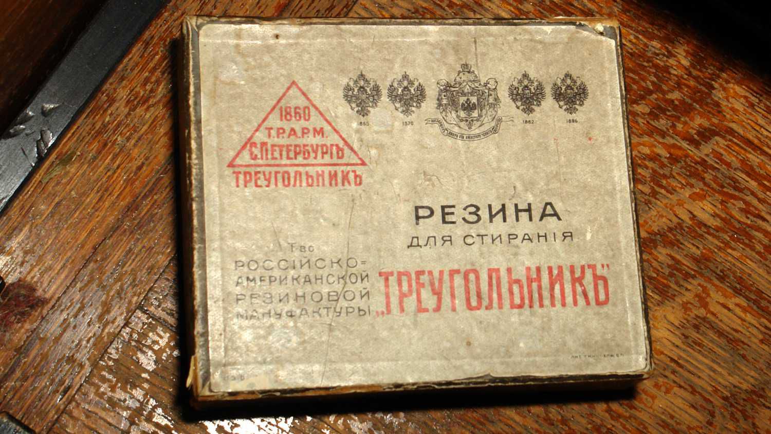 Старая коробка резинки «Треугольникъ» от Т-ва Российско-Американской Резиновой Мануфактуры, Санкт-Петербург, с гербами и надписью «Резина для стирания».