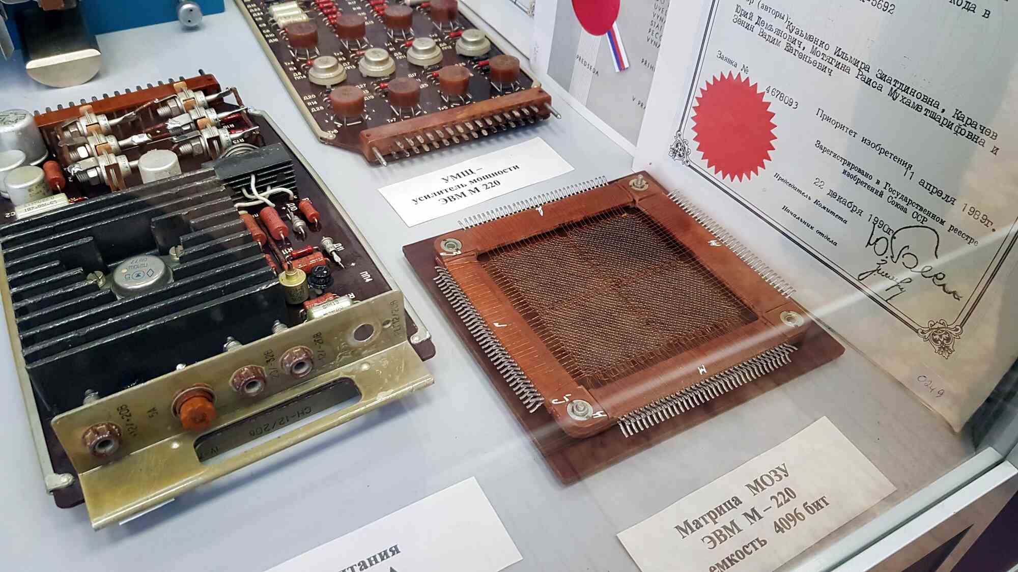 На выставке представлены электронные компоненты ЭВМ М-220: усилитель мощности УМП, матрица МОЗУ ёмкостью 4096 бит и свидетельство о приоритете изобретения от 11 апреля 1989 г.