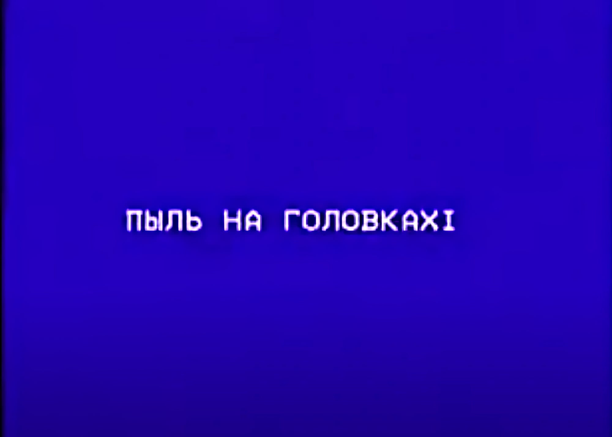 На синем фоне белым пиксельным шрифтом написано «ПЫЛЬ НА ГОЛОВКАХІ» — сообщение об ошибке воспроизведения видеокассеты.
