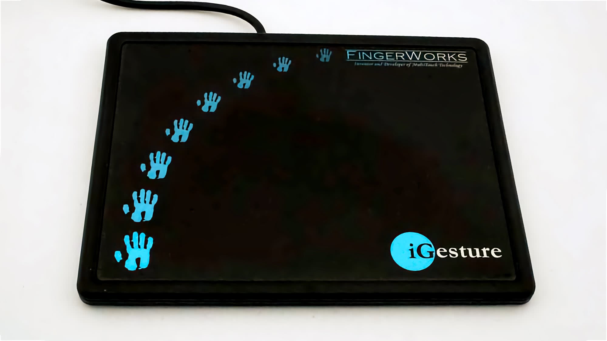Чёрный планшет FingerWorks с логотипом iGesture и синими отпечатками ладоней, демонстрирующий технологию мультитач.